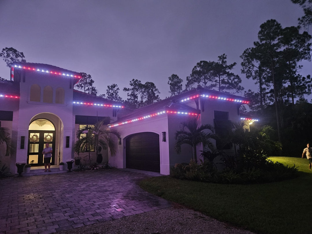 Oelo permanent roofline lights repaired by Perks Smart Solutions in Naples, Florida — red, white, and blue lights glowing along the roofline at dusk
